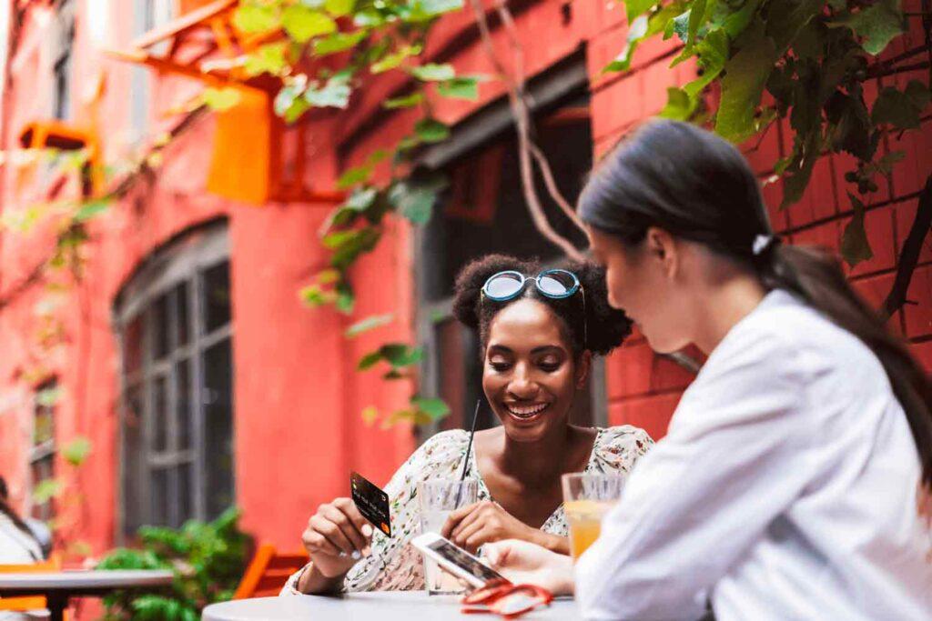 Deux femmes téléchargent l'application PayTrip